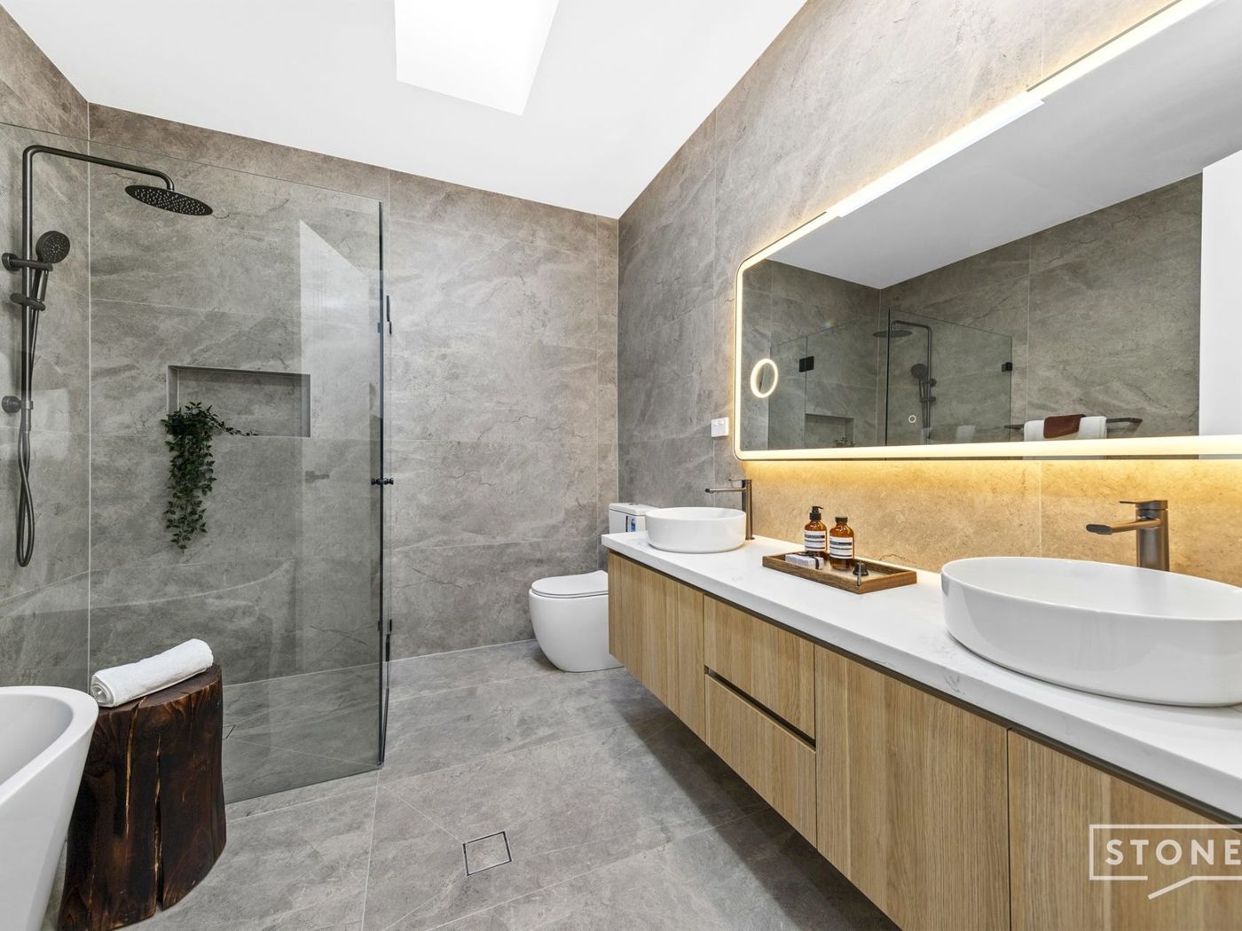 Stone tiled bathroom with skylight